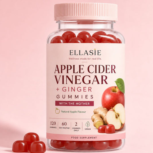 A bottle of Ellasie Apple Cider Vinegar + Ginger Gummies with a pink cap and label, shown on a soft pink background with several red gummies scattered in front.