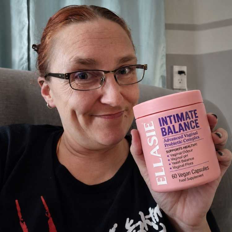Person holding a pink container labeled 'Intimate Balance' by Ellasie.