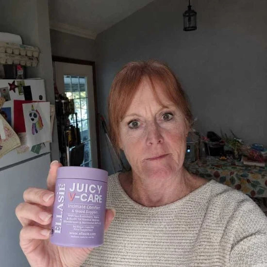 Person holding a purple container labeled 'Juicy Care' in a home setting.