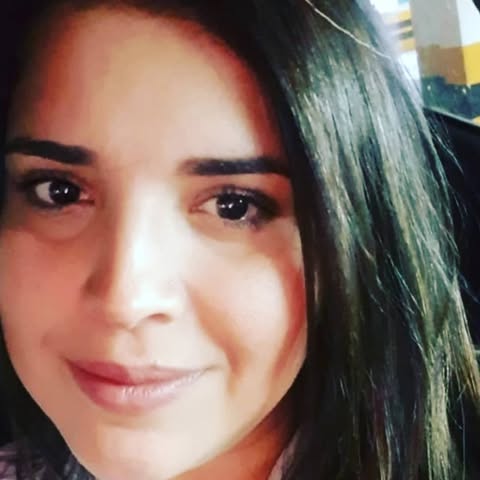 Close-up of a person with dark hair and a blurred background