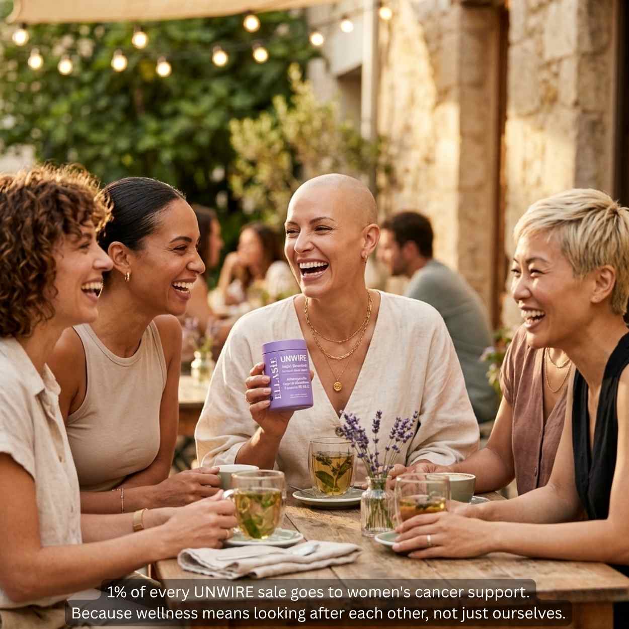 Group of women laughing and enjoying drinks outdoors with a bottle of Ellasie UNWIRE product.