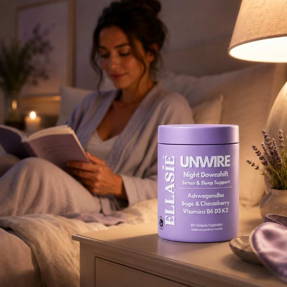 Woman reading a book in bed with a purple container of Ellasie Unwire supplement on the nightstand.